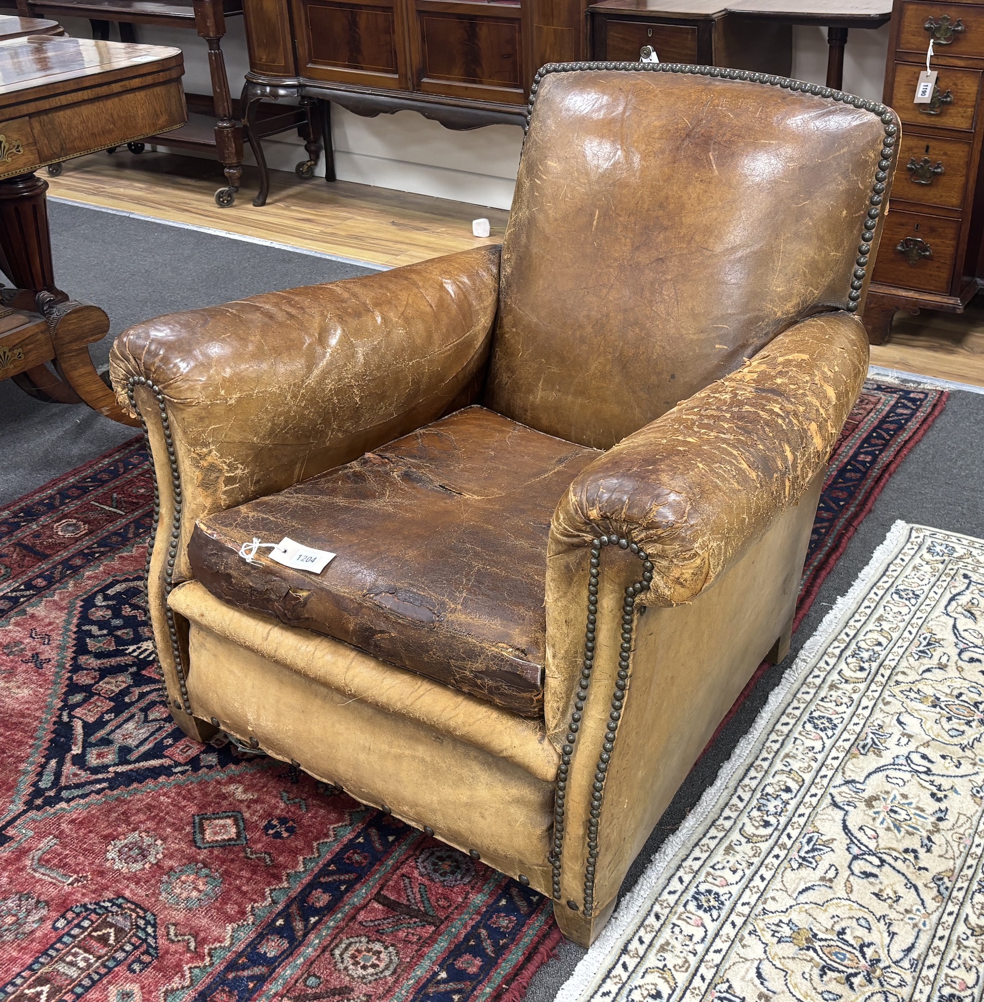 An early 20th century French studded tan leather club chair, width 64cm, depth 72cm, height 77cm